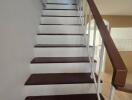 Staircase with wooden steps and white railing