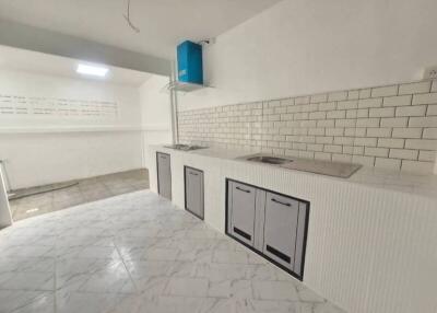 Modern kitchen with white tiled backsplash and marble flooring