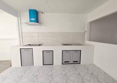 Modern kitchen with white brick backsplash and blue range hood