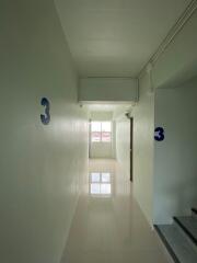 hallway in a building with white walls and large windows
