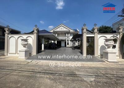 Exterior view of a house with gated entrance and driveway