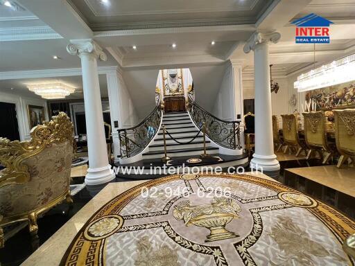 Luxury interior with ornate staircase, dining area, and regal furnishings