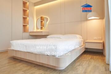 Modern bedroom with bed, decorative lighting, and wooden flooring