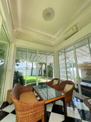 Sunroom with wicker chairs and glass table