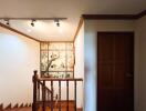 Decorated staircase landing with wooden railing and wall art