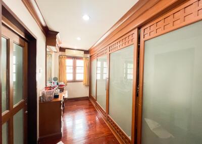 Well-lit hallway with wooden floor and frosted glass doors