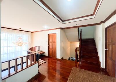 Spacious living area with wooden floors and staircase