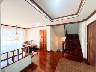 Spacious living area with wooden floors and staircase