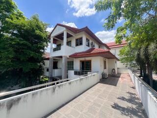 Two-story house with red tile roof and outdoor balcony