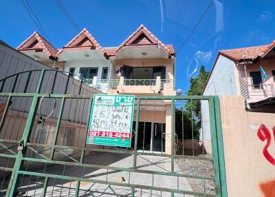 Two-story house with a fenced front yard and a for-sale sign