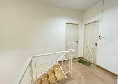 Hallway with wooden staircase and white doors