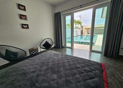 Bedroom with pool view through large windows