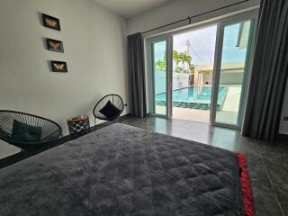 Bedroom with pool view through large windows