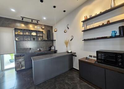 Modern kitchen with dark cabinetry and decorative shelving
