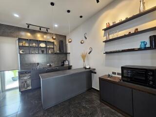 Modern kitchen with dark cabinetry and decorative shelving