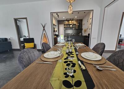 Modern dining room with elegant table setting leading to an open kitchen