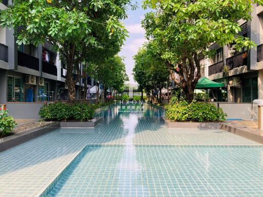 Outdoor pool with green trees and seating area