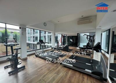 Modern gym with exercise equipment and large windows