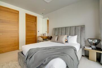 Bedroom with bed, wooden doors, and a dressing table