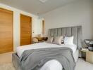 Bedroom with bed, wooden doors, and a dressing table