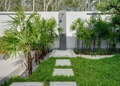 Lush garden area with outdoor shower and pathway