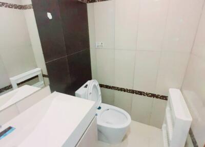 Modern bathroom with tiled walls and a toilet