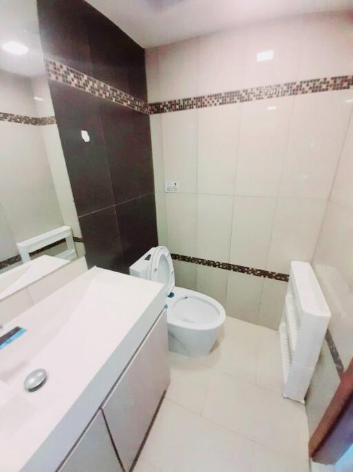 Modern bathroom with tiled walls and a toilet