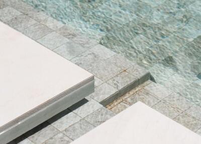 Swimming pool with stone tile flooring and lounging area