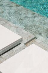 Swimming pool with stone tile flooring and lounging area