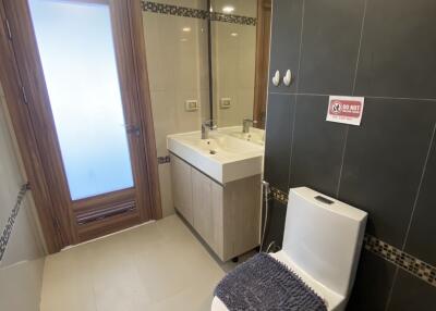 Modern bathroom with toilet, sink, and mirror