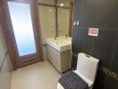 Modern bathroom with toilet, sink, and mirror