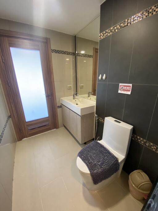 Modern bathroom with toilet, sink, and mirror