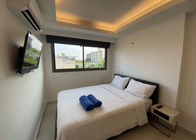 Modern bedroom with a double bed, window, and ceiling lighting