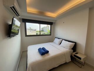 Modern bedroom with a double bed, window, and ceiling lighting