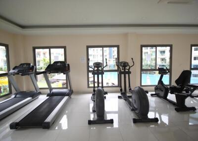 Modern in-house gym with various equipment and pool view