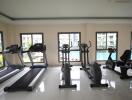 Modern in-house gym with various equipment and pool view