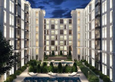 Exterior view of a modern apartment complex at night with well-lit windows and landscaped courtyard.