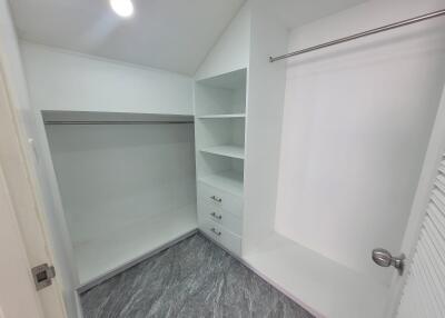 Spacious walk-in closet with shelving and drawers