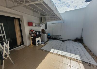 Covered patio with tiled flooring and small garden area