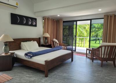 Spacious bedroom with large windows and balcony view