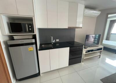 Modern kitchen space with appliances and a TV in an open-concept area