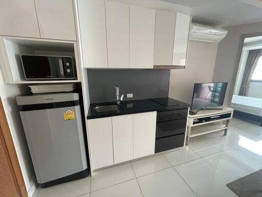 Modern kitchen space with appliances and a TV in an open-concept area