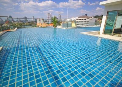 Outdoor rooftop swimming pool with cityscape in the background