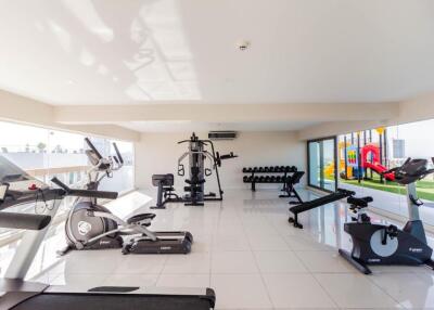 Bright and spacious gym with exercise equipment and large windows