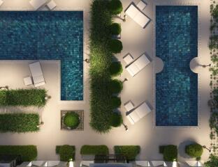 Aerial view of an outdoor pool area with lounge chairs and greenery