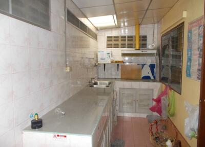 A simple kitchen with metal countertops and tiled walls.