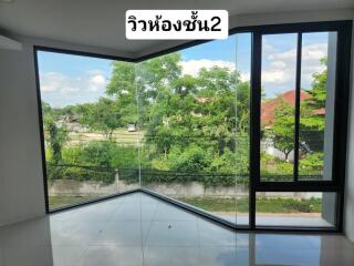 Living room with wide glass windows and lush green view