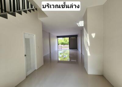 Spacious empty unfurnished room with staircase and roller shutter door. Clean and bright interior with polished floors