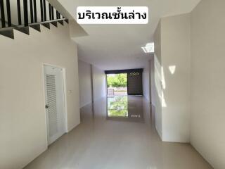 Spacious empty unfurnished room with staircase and roller shutter door. Clean and bright interior with polished floors