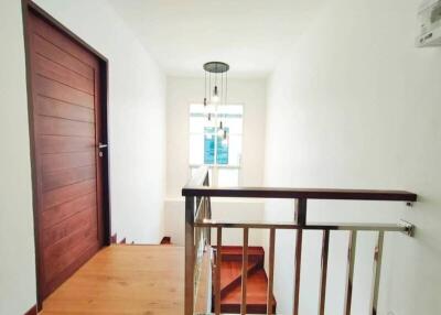 Bright hallway with wooden floor and modern light fixture